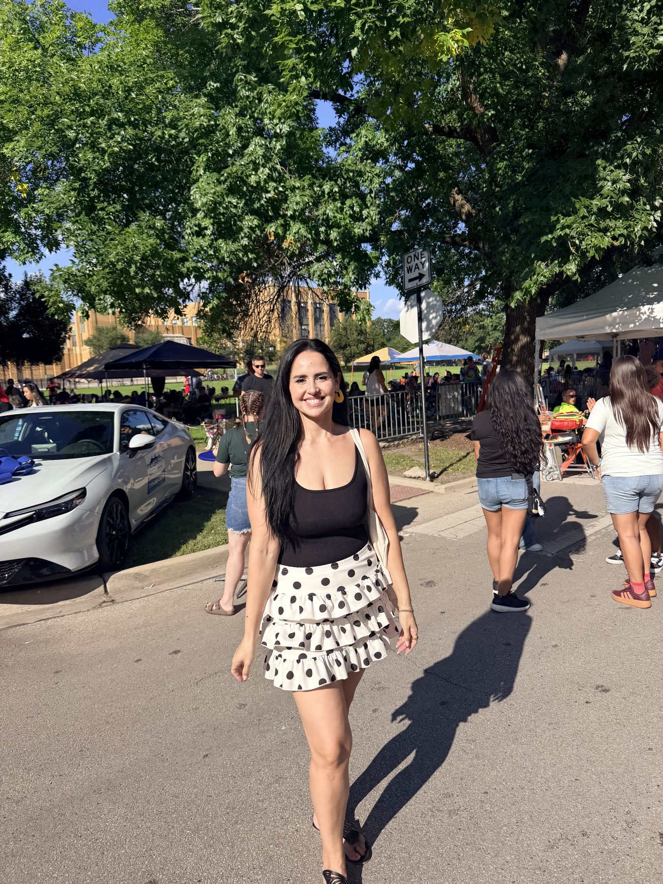Dra. Perez walking down a sunny street at a neighborhood festival